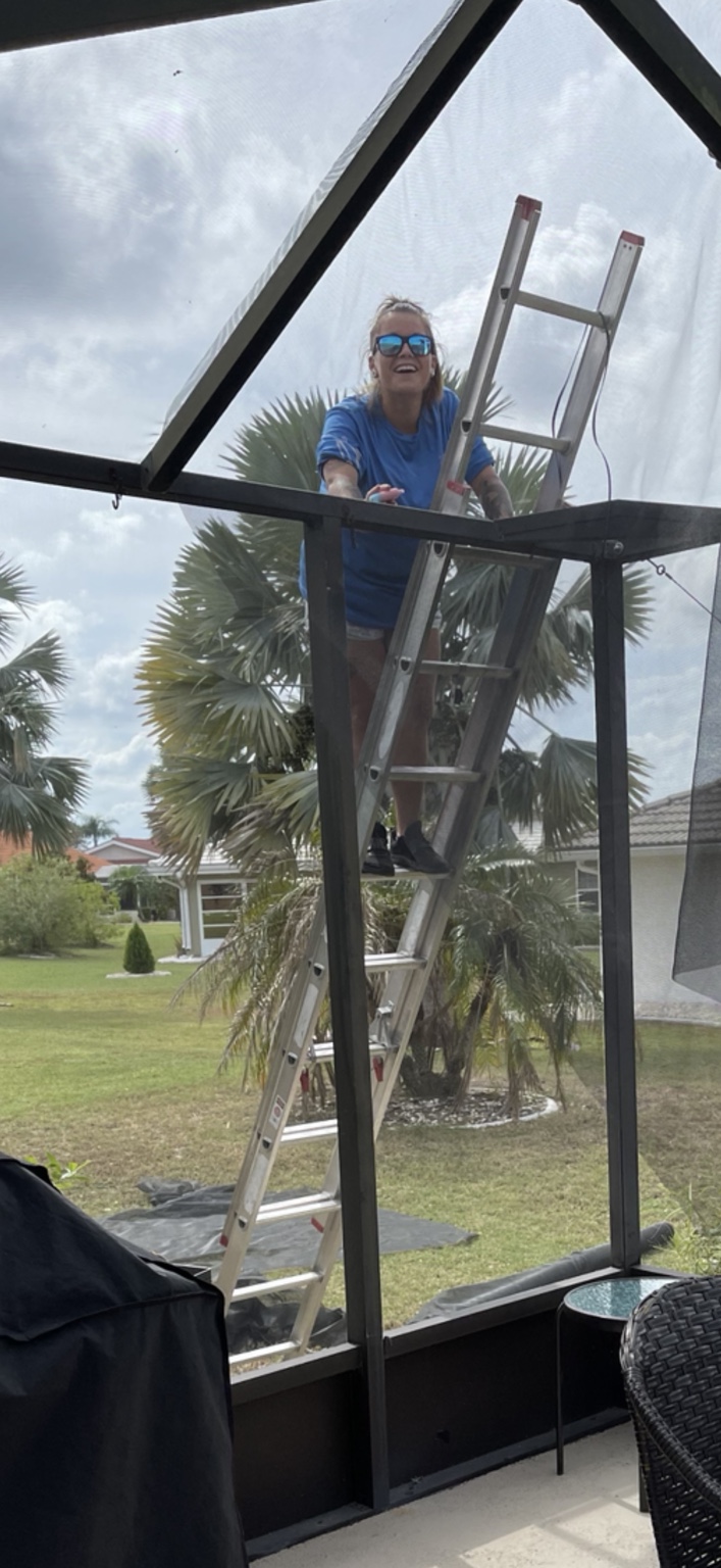 Crystal working on a ladder in an enclosure