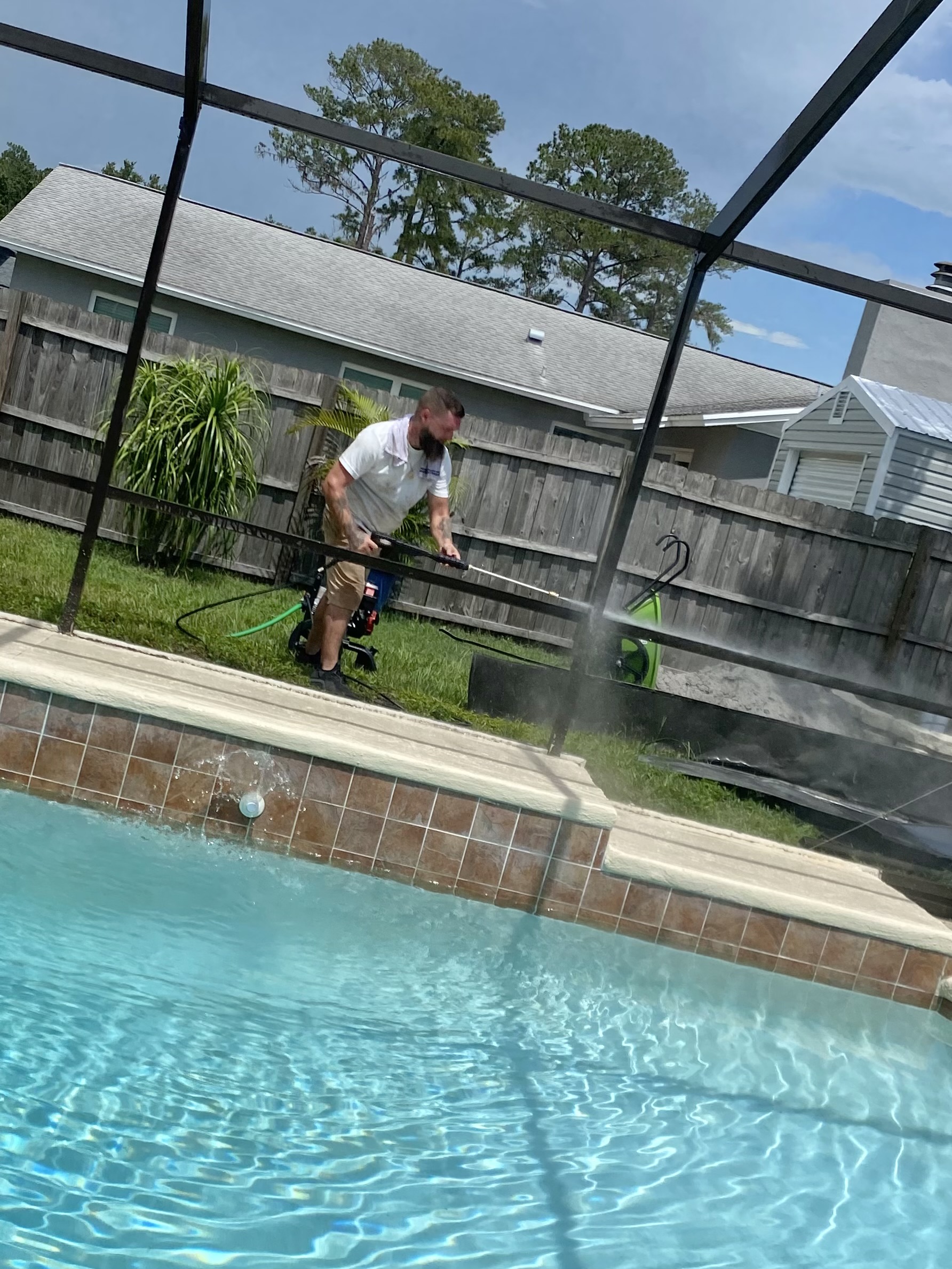 Lucas pressure washing an enclosure frame